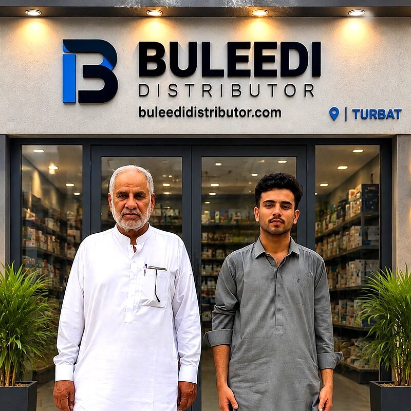 Haji Manzoor Baloch, left, and Mustaja Fazal, right, the administrators of Buleedi Distributors, standing together at the front of the business in Turbat, beneath the shop signboard.